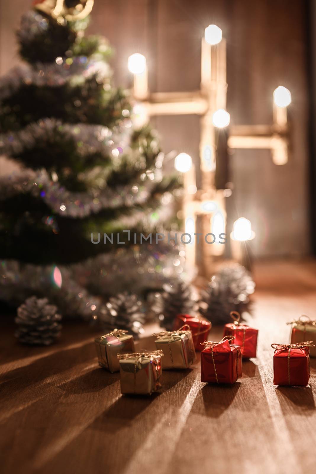 Christmas decorative tree is adorned with rain stands on the table with a lit lamp lights