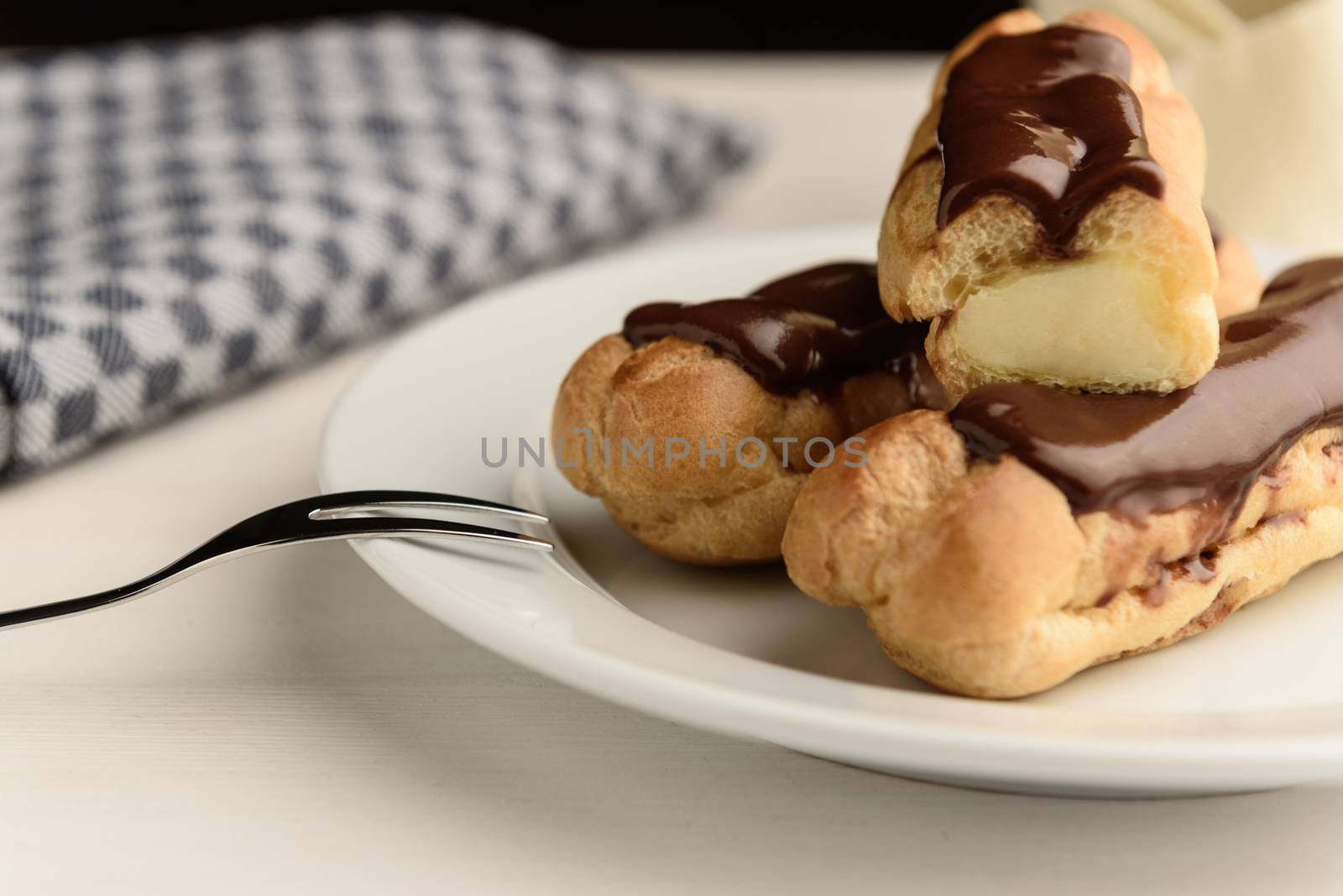 profiteroles with butter cream and chocolate topping on the plate