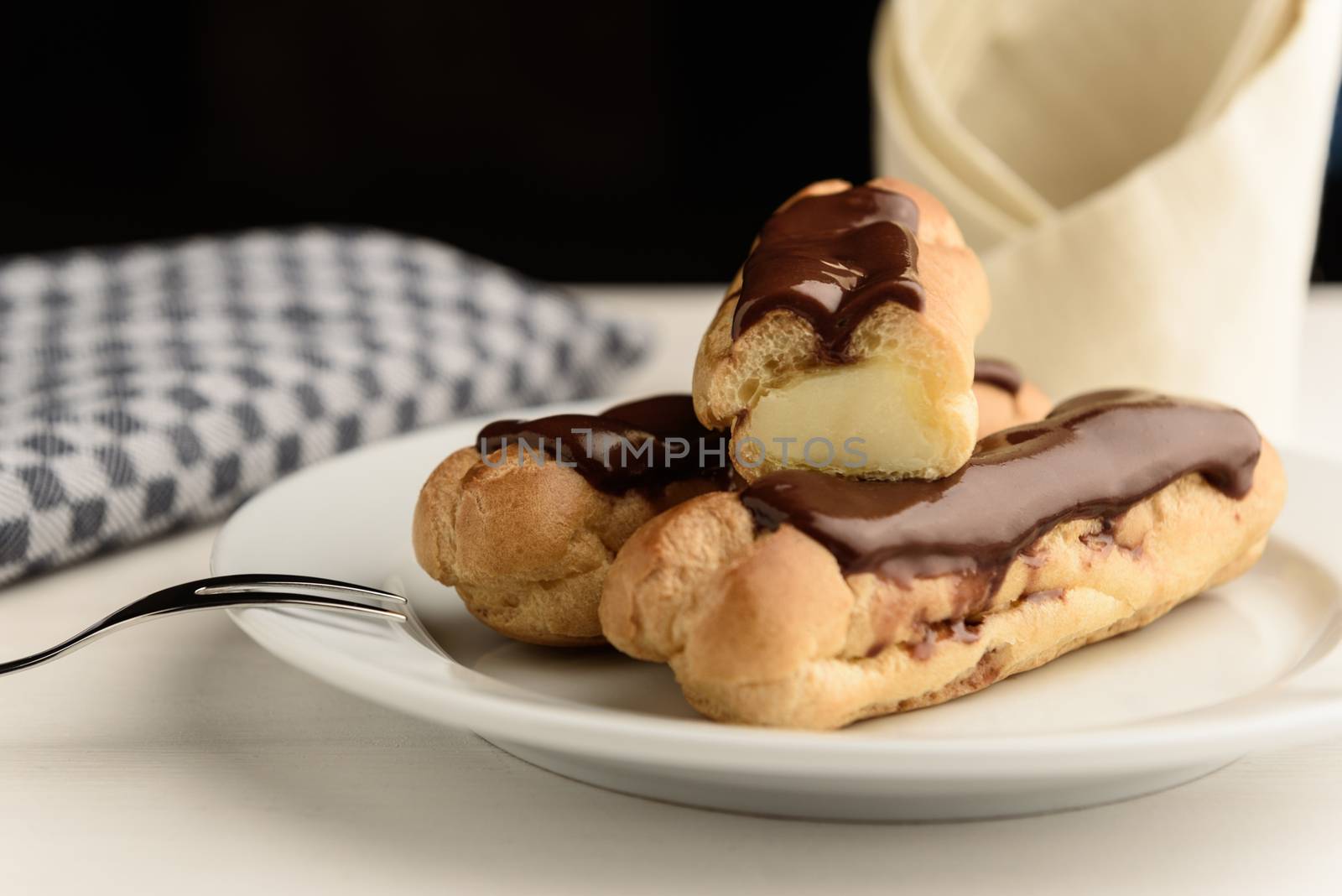 profiteroles with butter cream and chocolate topping on the plate