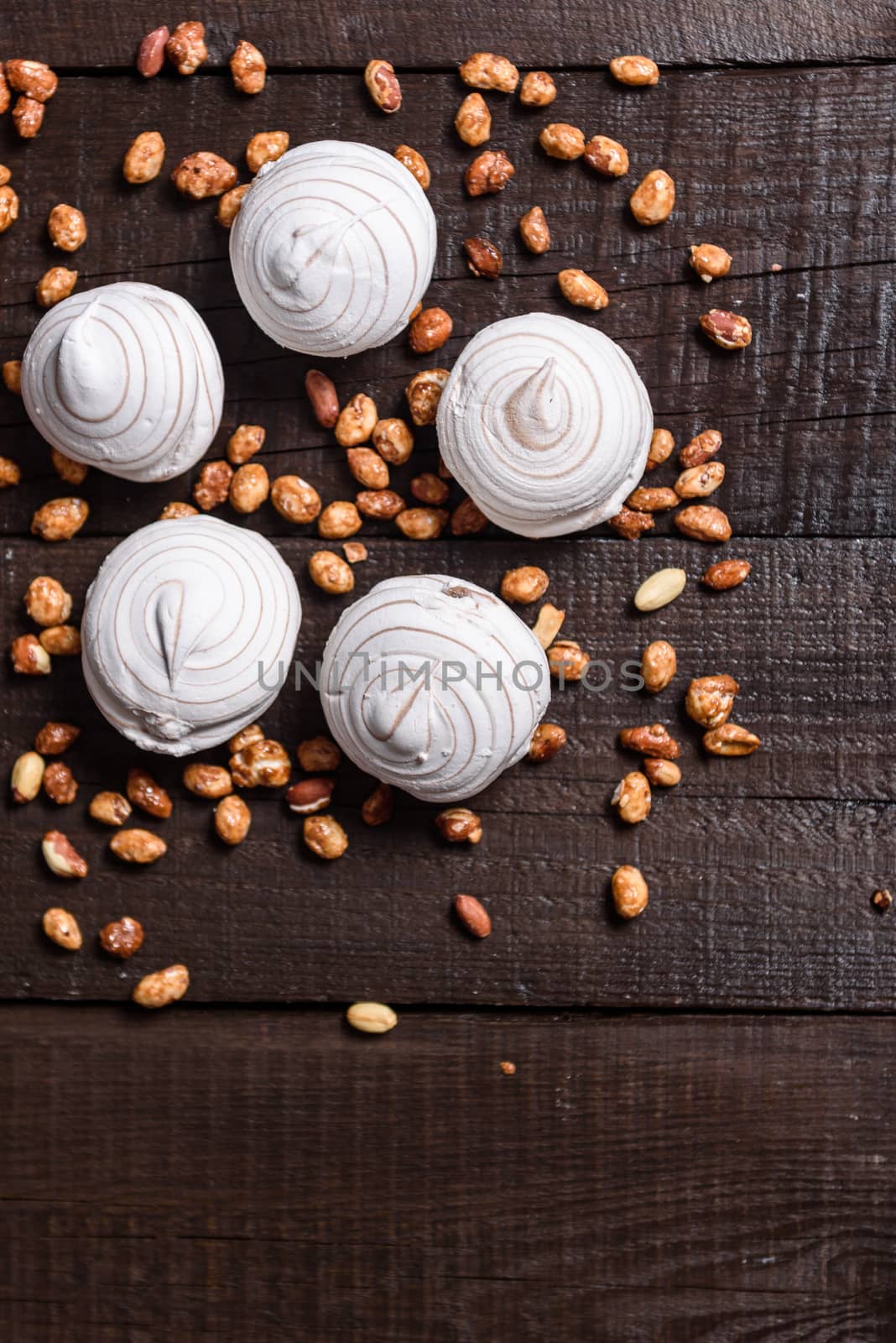 white marshmallows and sweet peanuts on the plate and wood