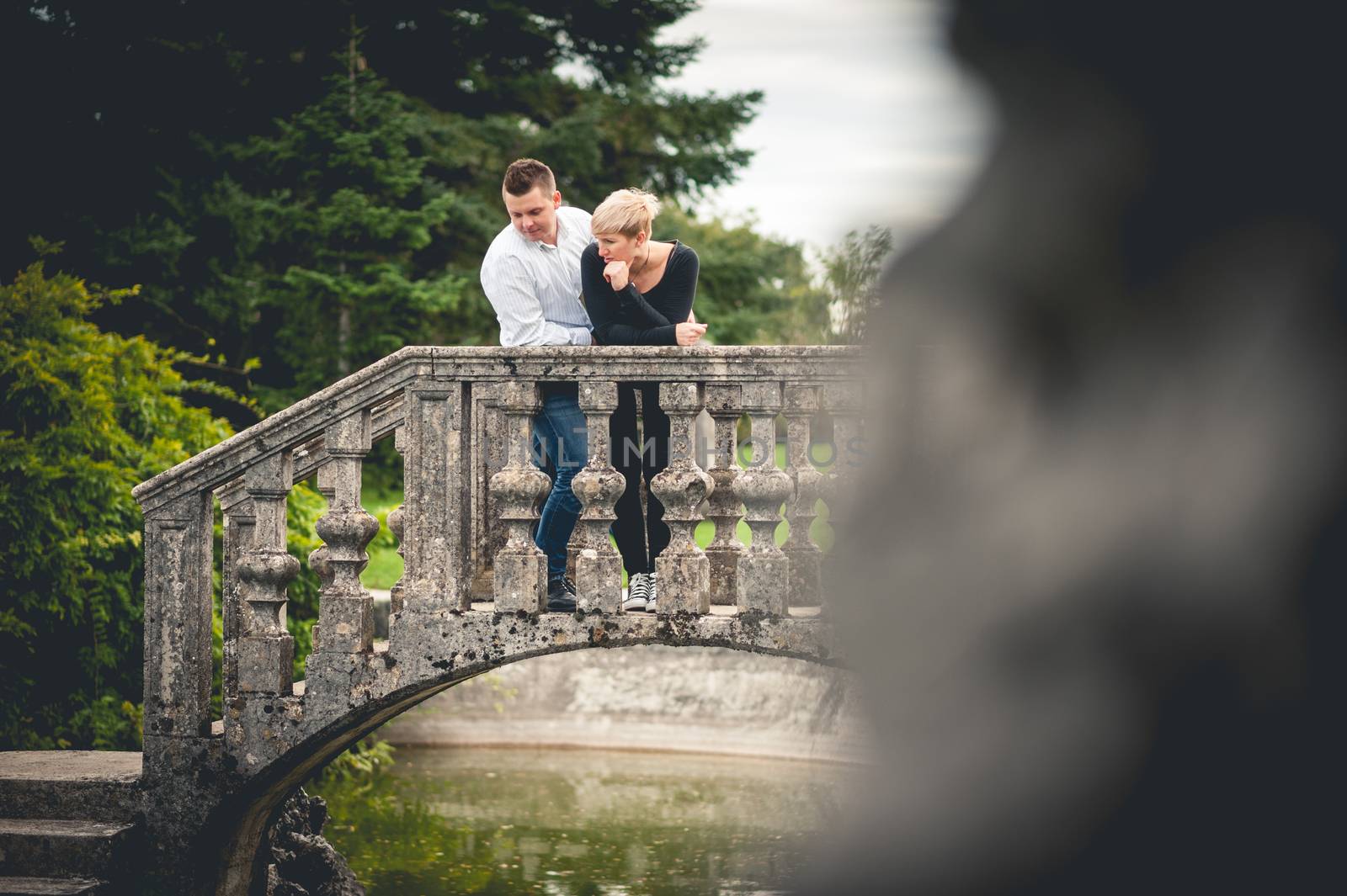 Young couple hugging on bridge  by fotoutrinek