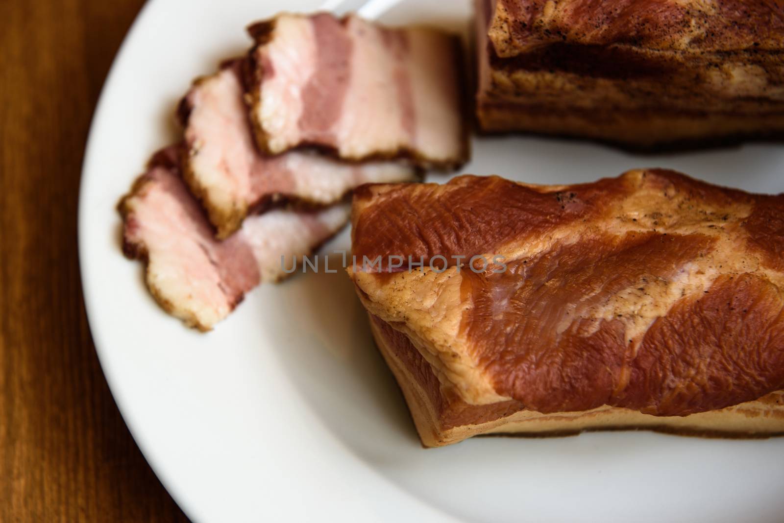 smoked pork ribs on white plate on wooden background