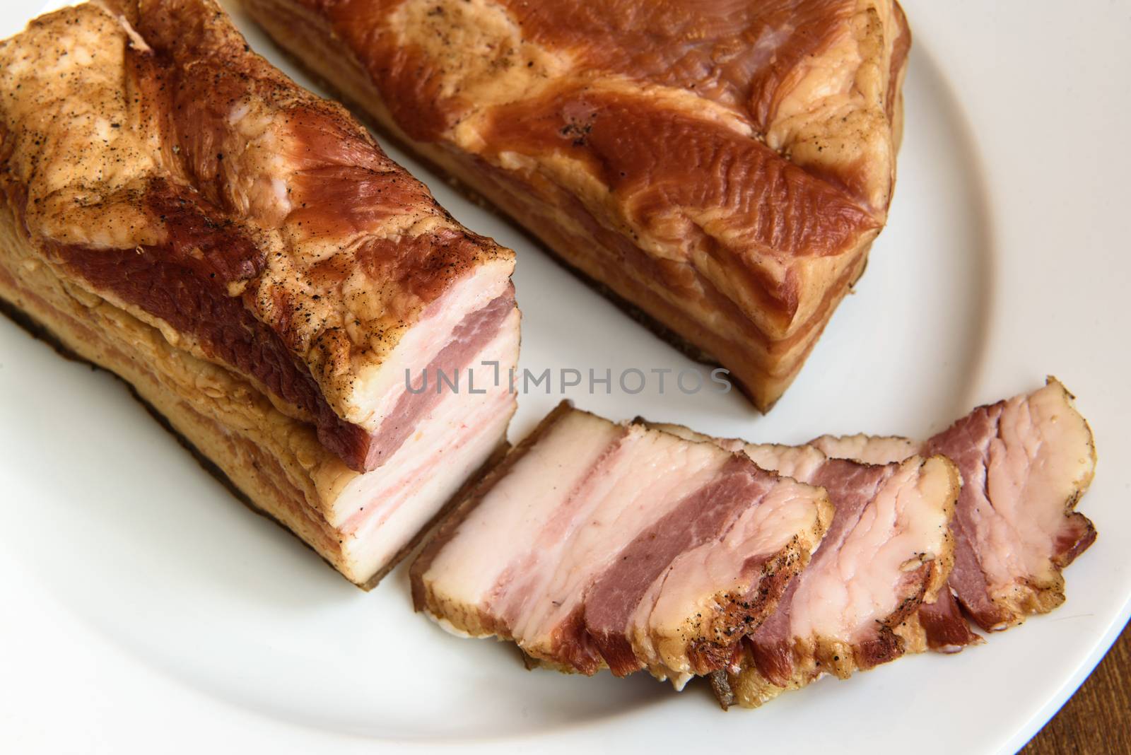 smoked pork ribs on white plate on wooden background