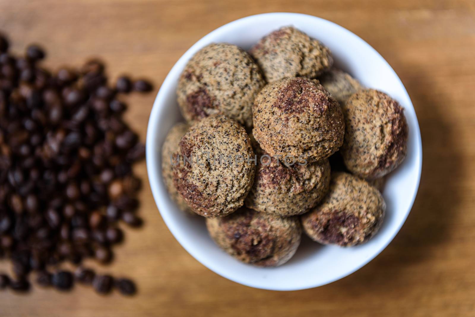 coffee cookies in a white plate with coffee beans on wooden brown table