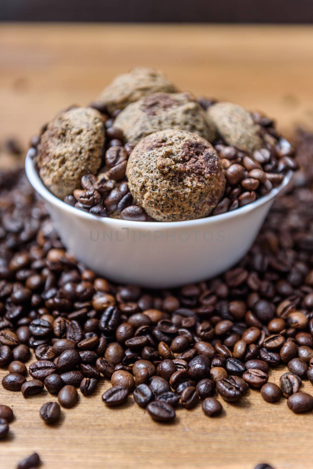 coffee cookies in a white plate with coffee beans on wooden brown table