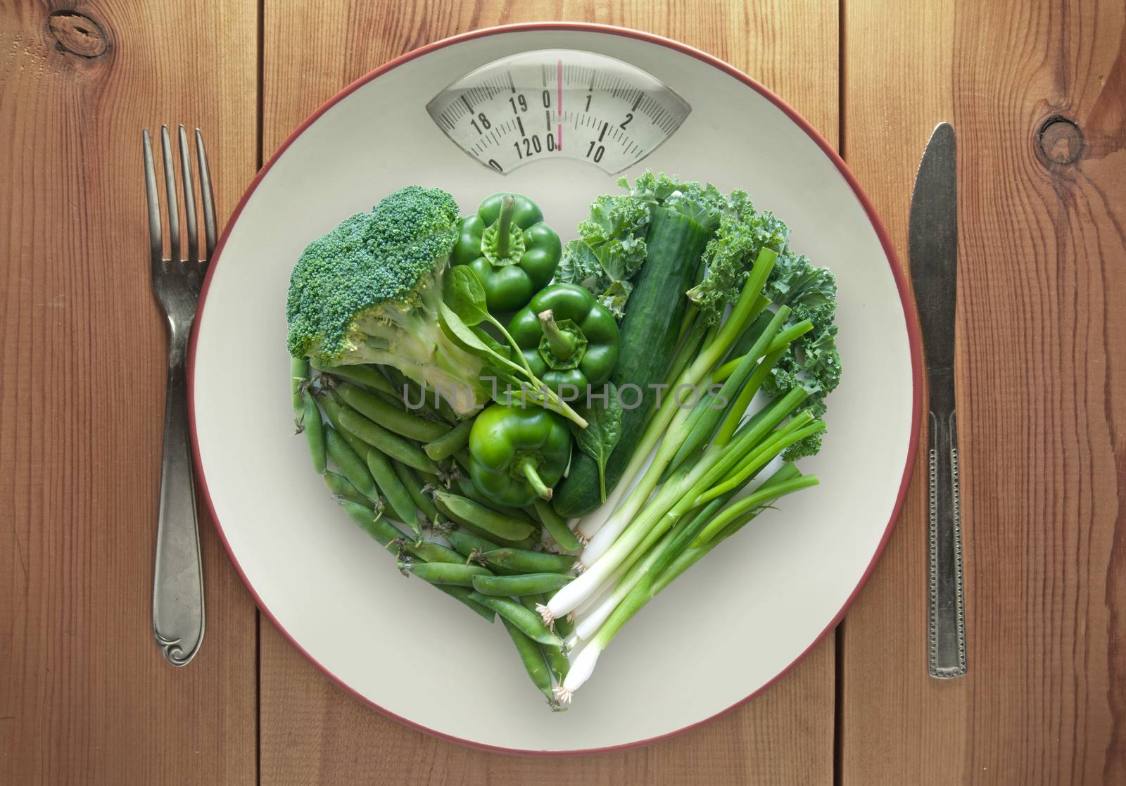 Plate with weighing scales packed with vegtables in a heart shape