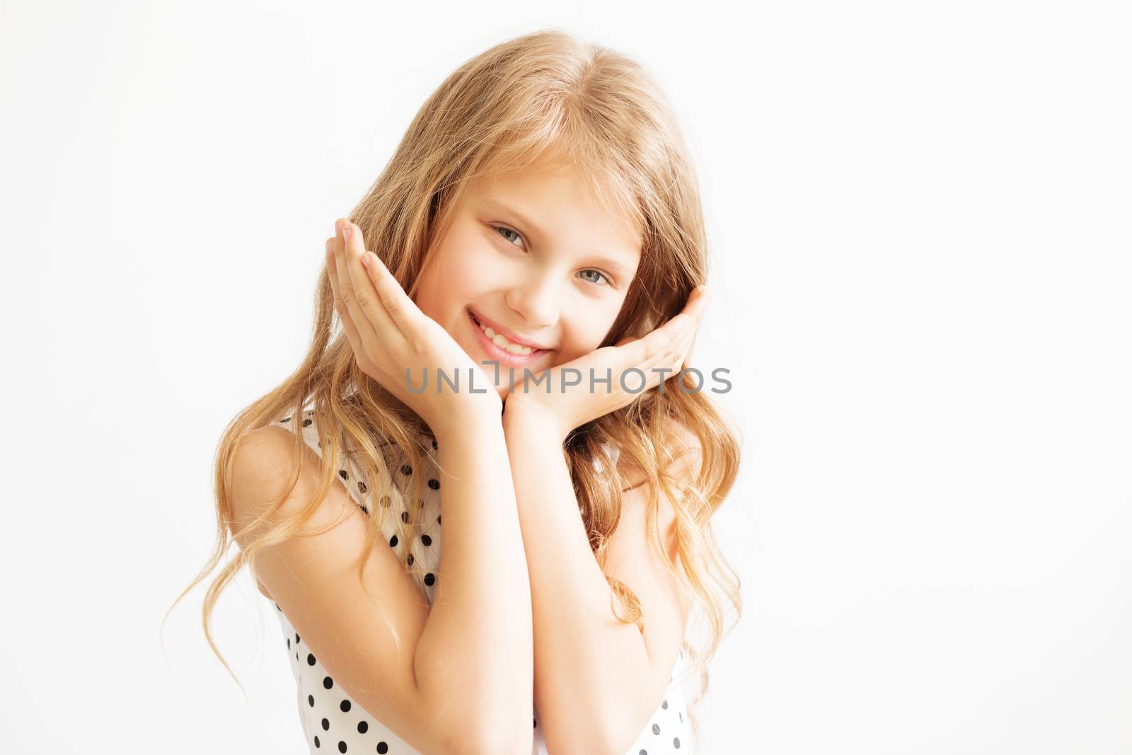 Closeup portrait of a lovely playful little girl in front of white background