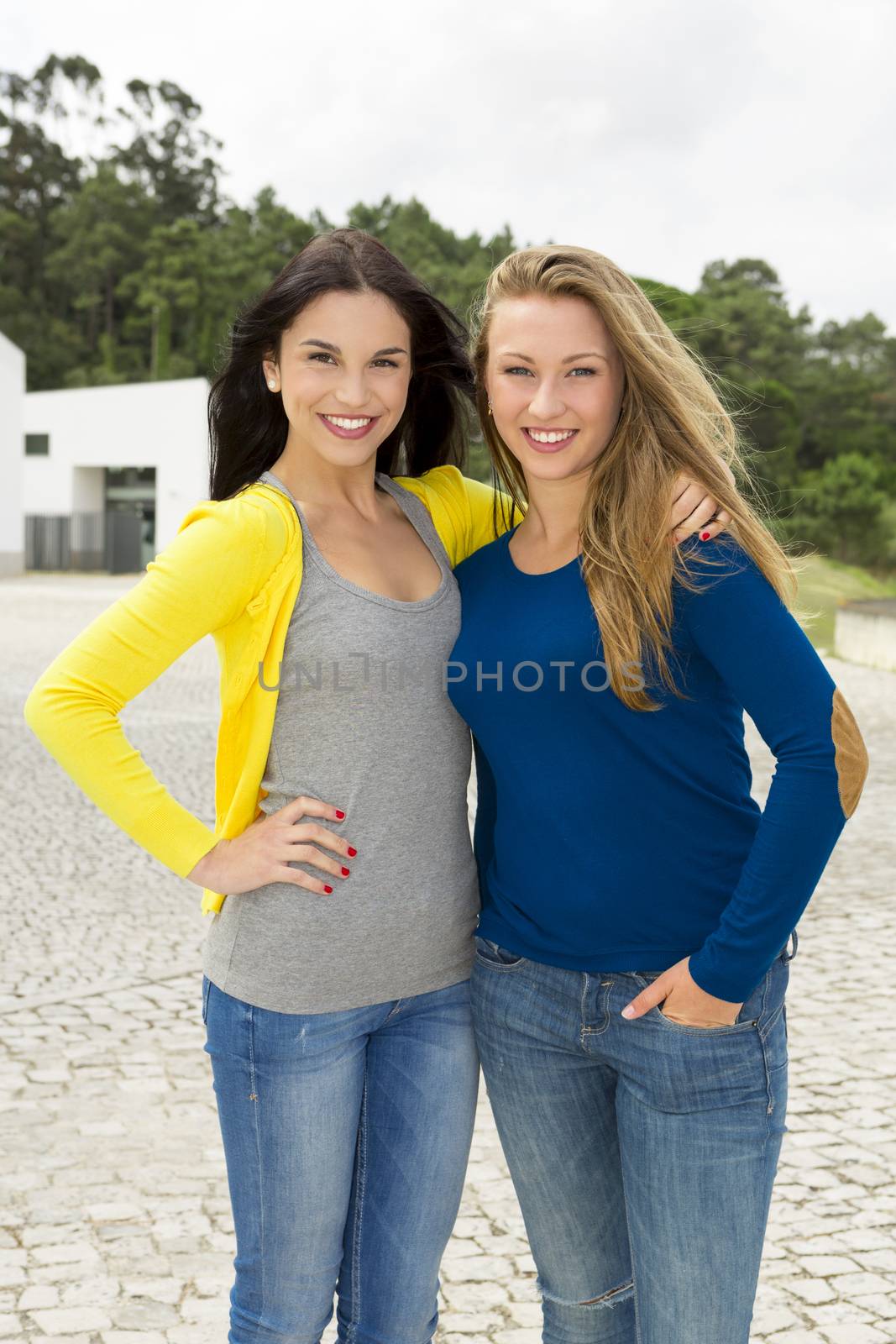 Two happy and beautiful teenage students in the school 