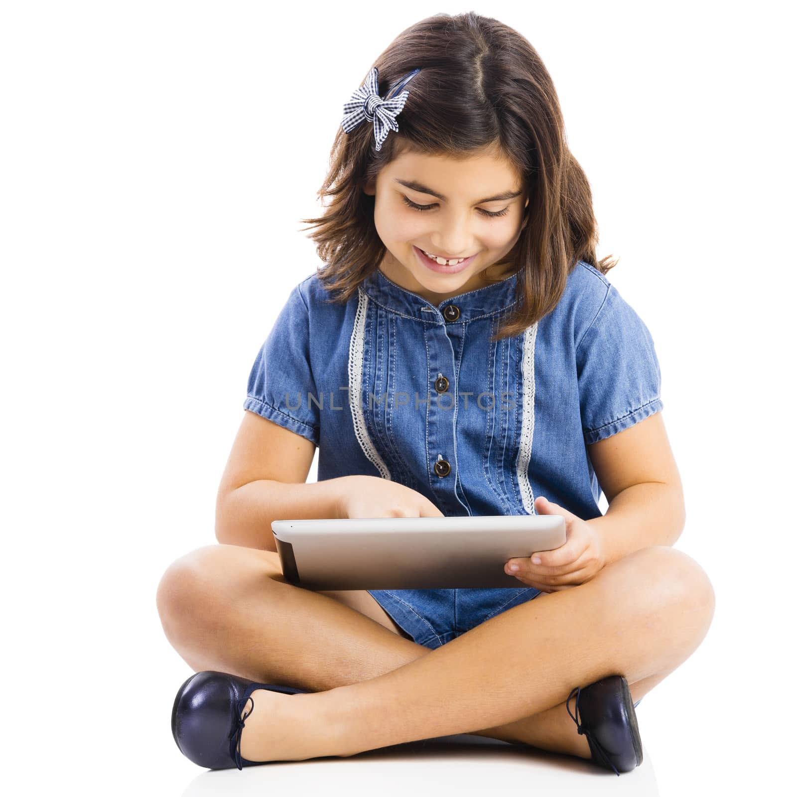 Young girl sitting on floor and using a tablet