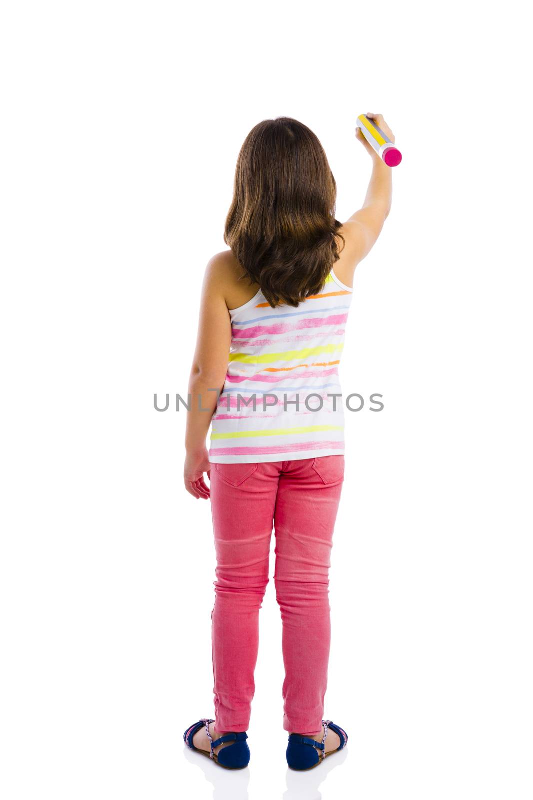 Beautiful young girl holding a big pencil and writing something on a glass wall