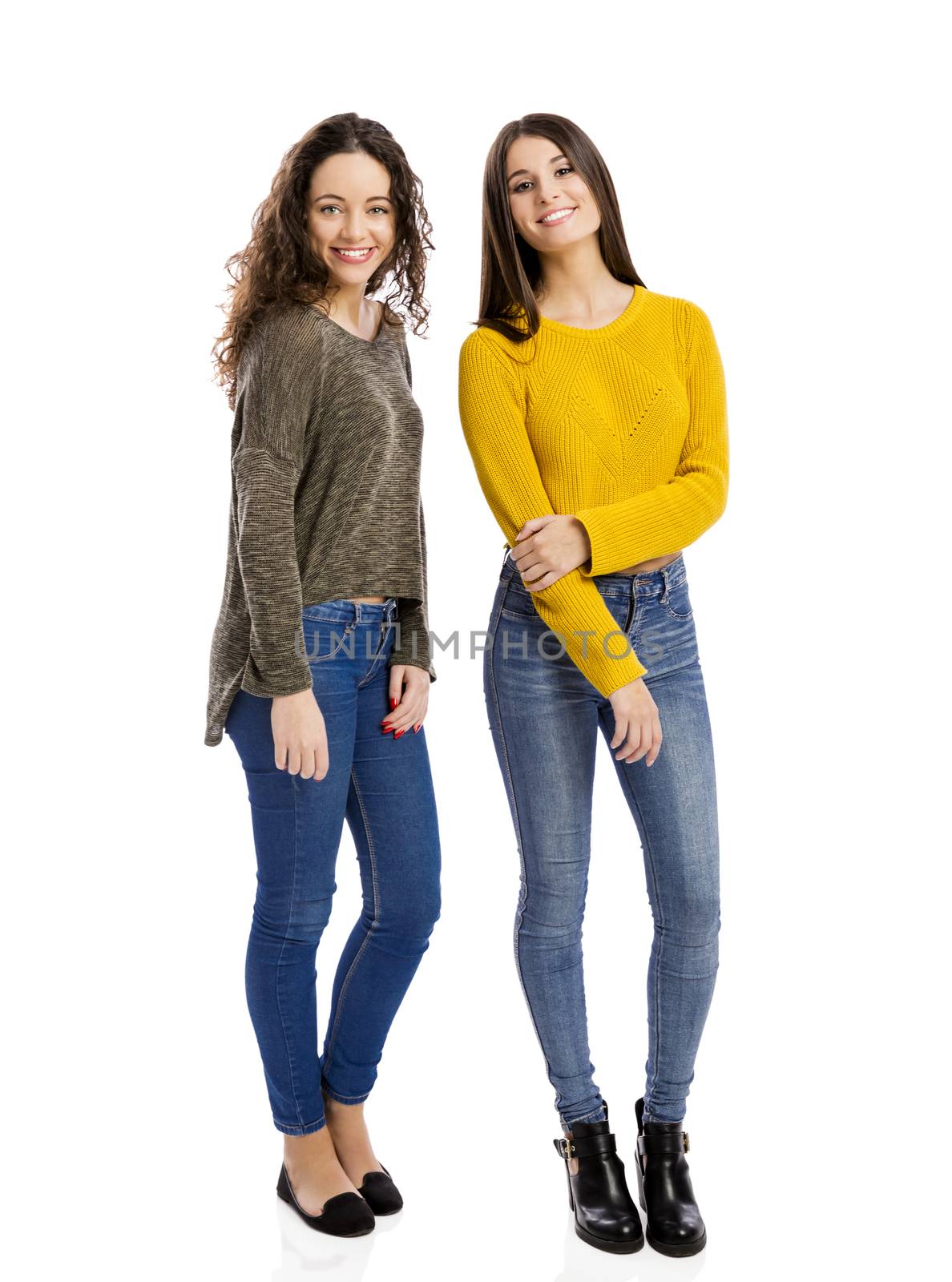 Studio portrait of two beautiful girls smiling