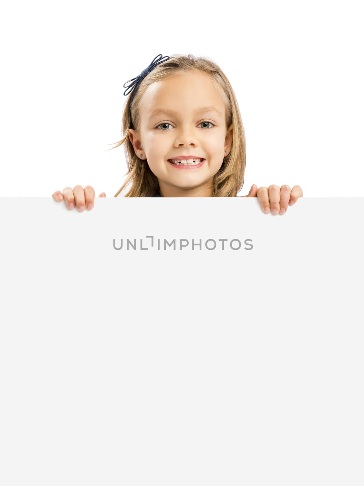 Beautiful little girl holding and showing something on a whiteboard