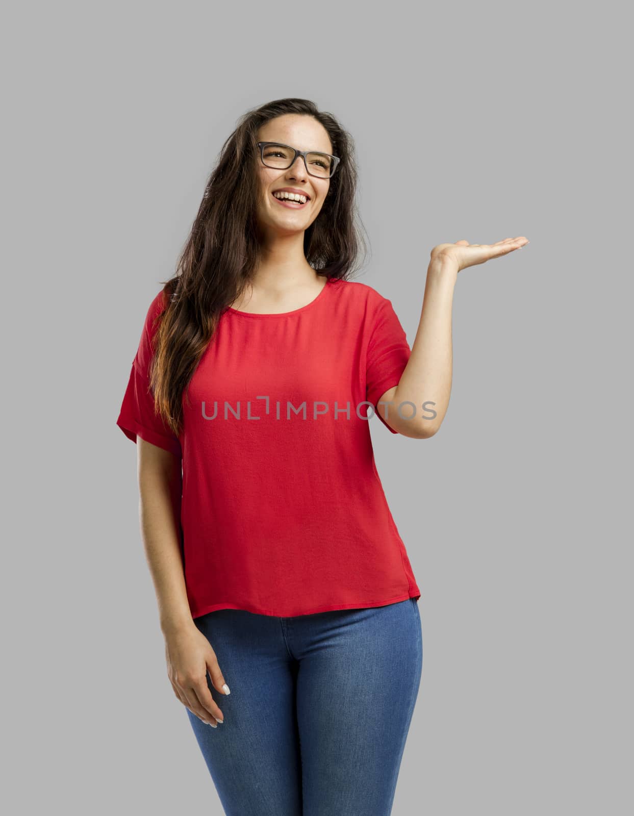 Lovely happy woman showing something on her hand, isolated over white background 