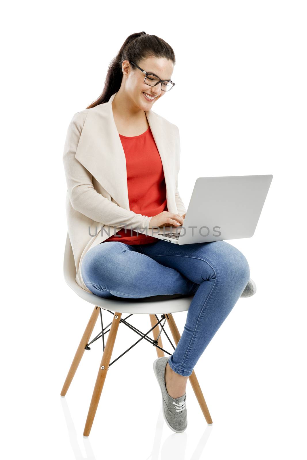 Beautiful and happy woman working with a laptop, isolated over white background 