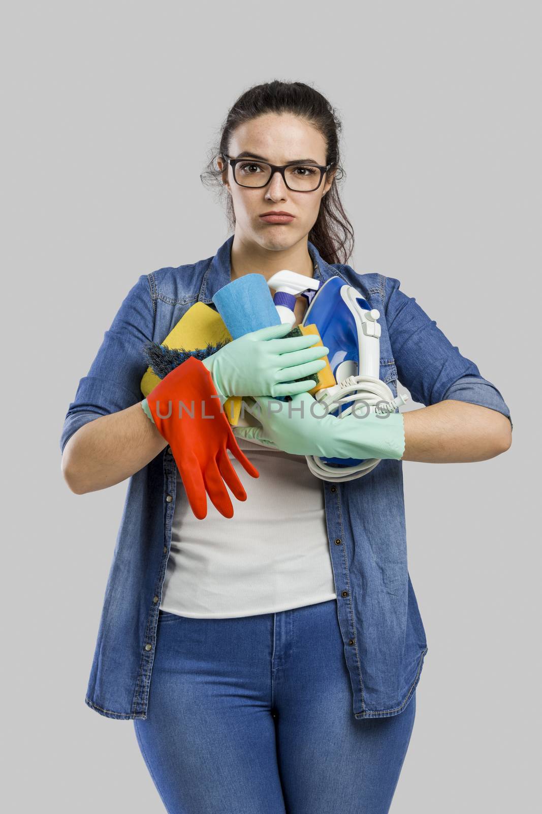 Portrait of a tired woman with hands full on cleaning stuff