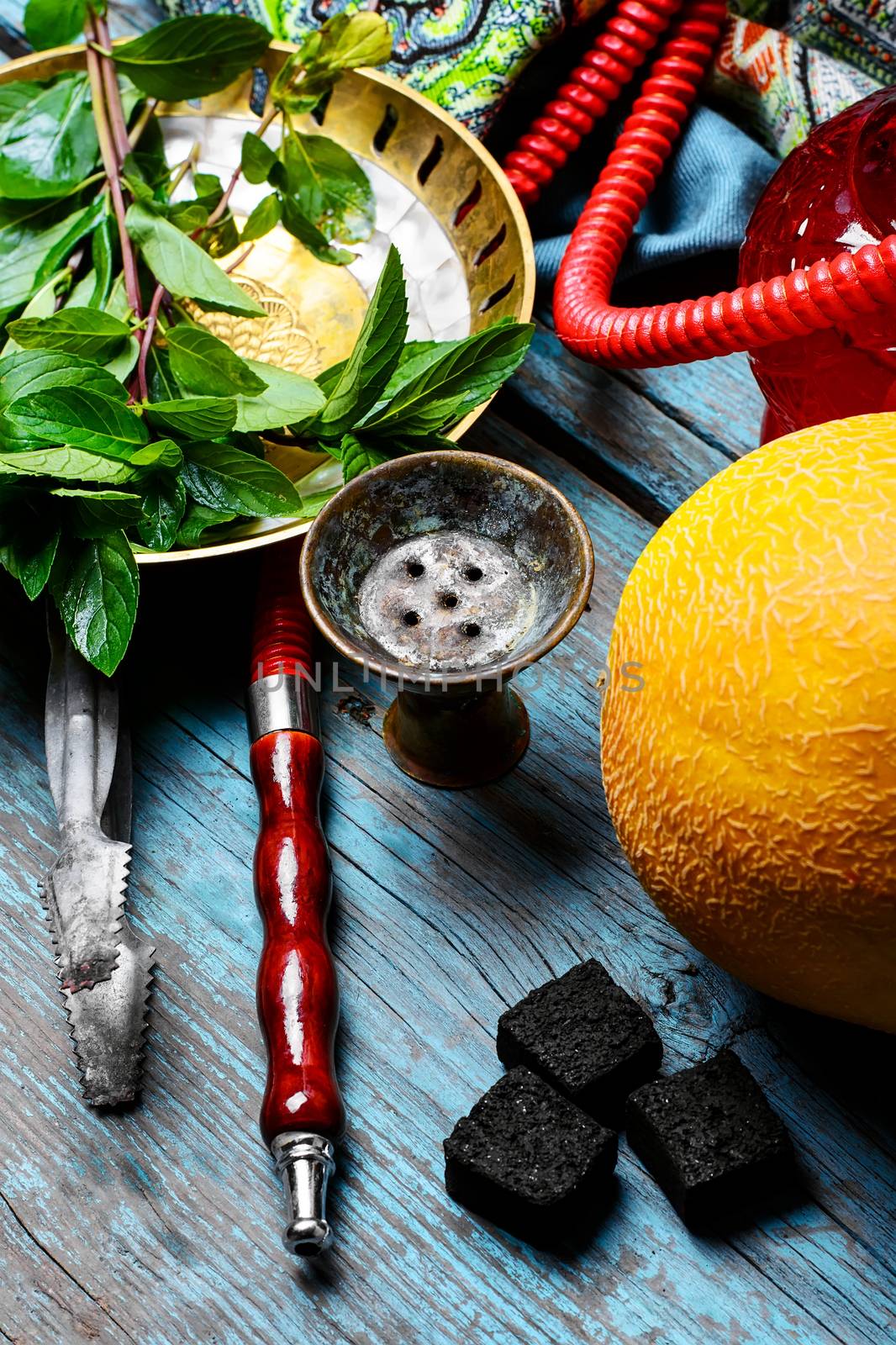 Still life with slices of ripe melon and smoking hookah