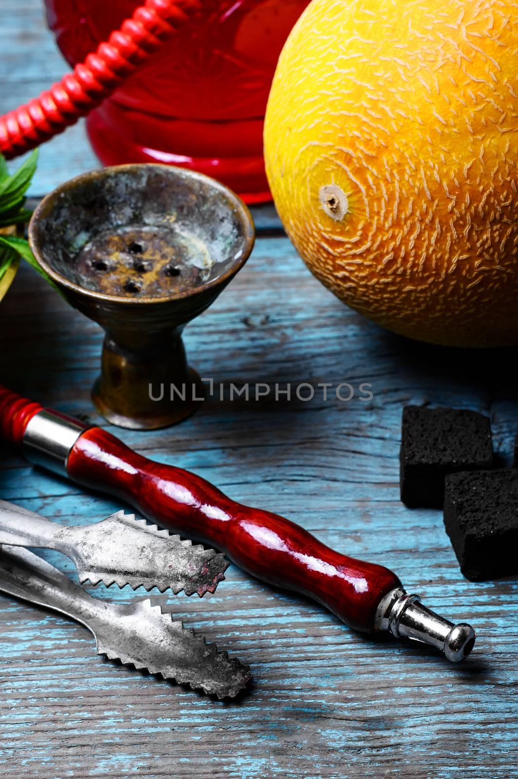 Still life with slices of ripe melon and smoking hookah