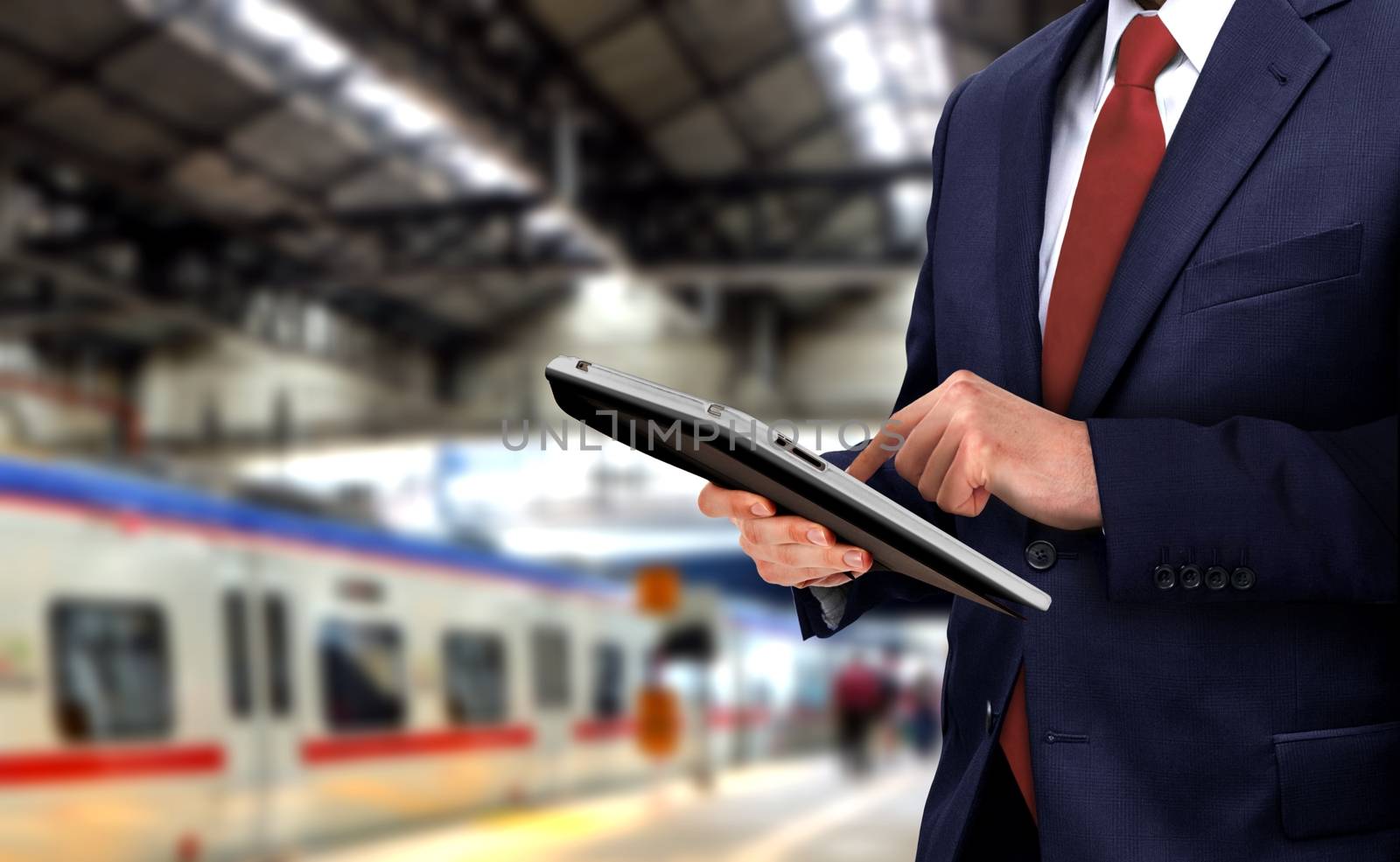 Businessman with touchpad at train station