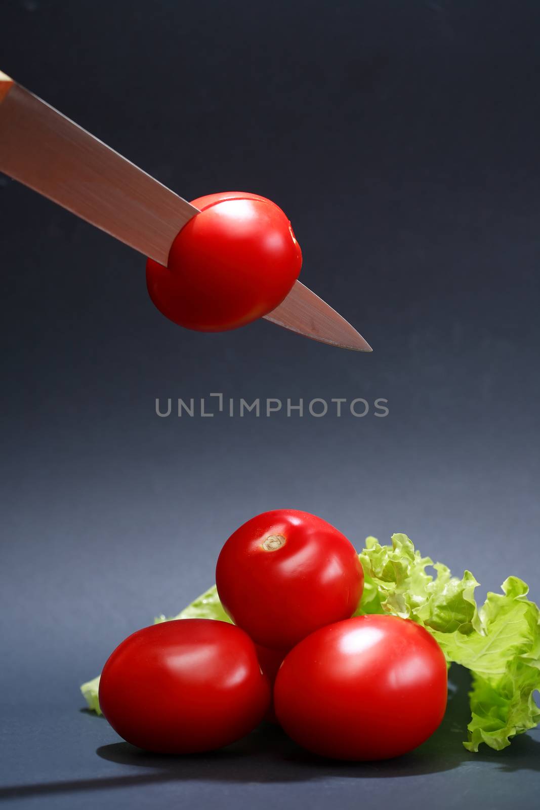 Cooking concept. Few freshness red tomatoes and knife on dark background