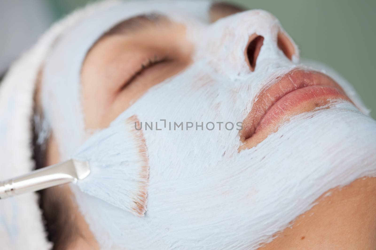 Woman receiving a facial mask treatment