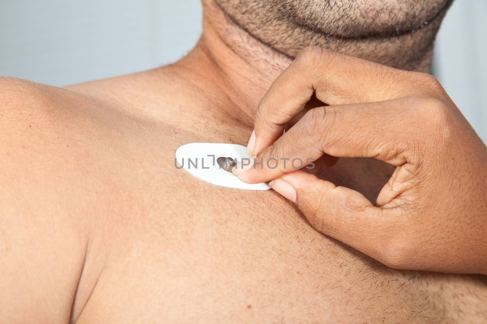 Nurse placing an electrode on patient's chest