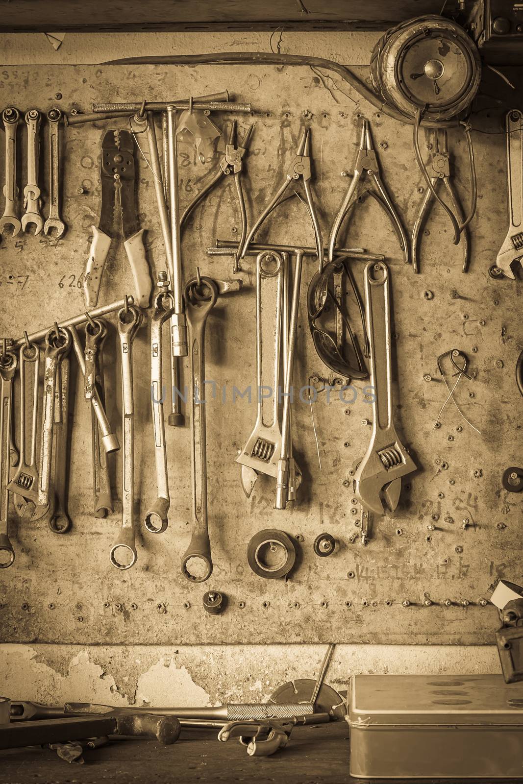 Old tools hanging on wall in workshop , Tool shelf against a wall vintage style