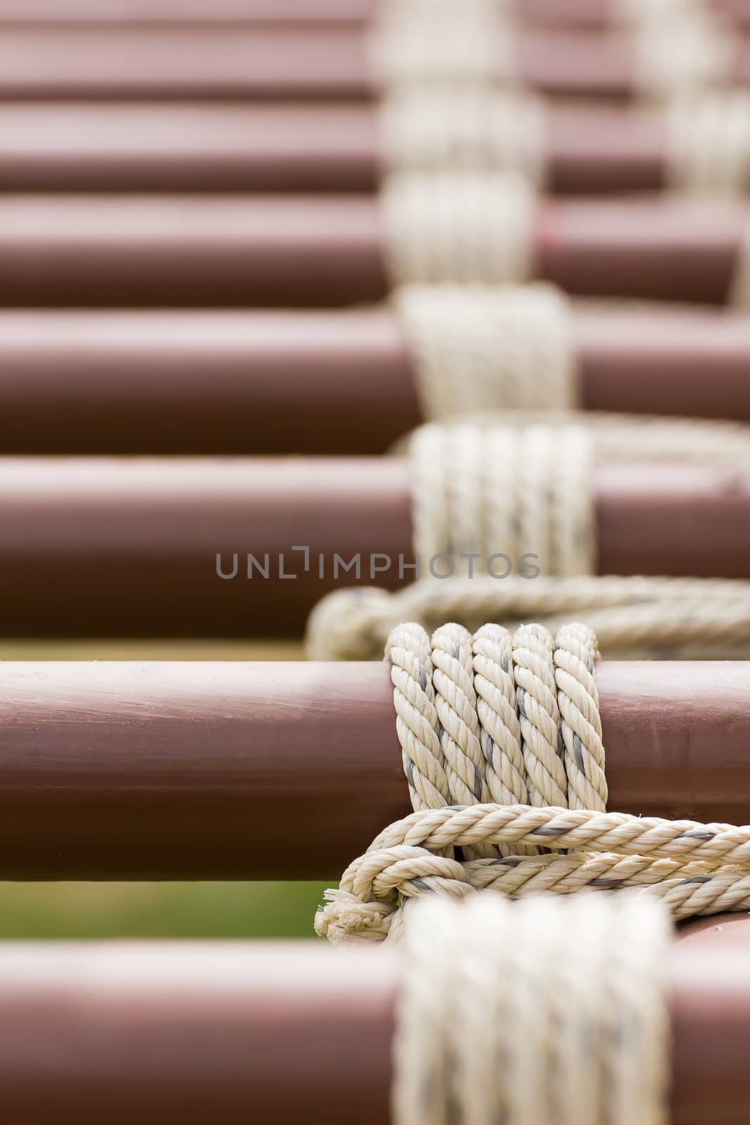 Close up of rope tied knot around metal pipe