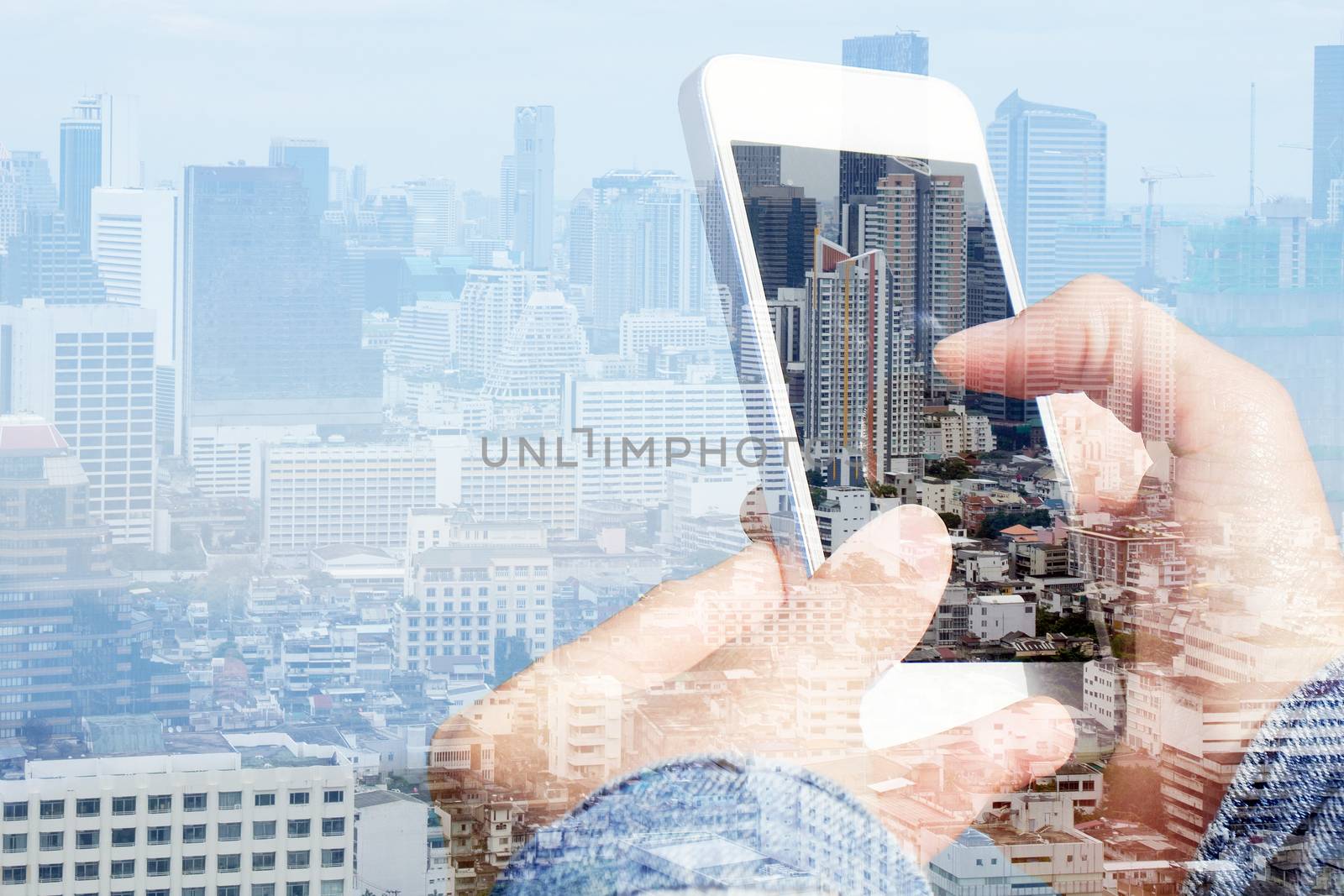 Double exposure image of using smart phone with cityscape background,Communication technology concept