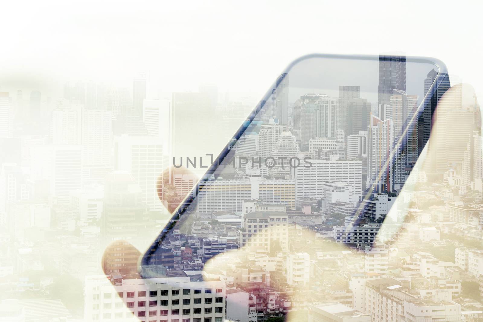 Double exposure image of using smart phone with cityscape background,Communication technology concept