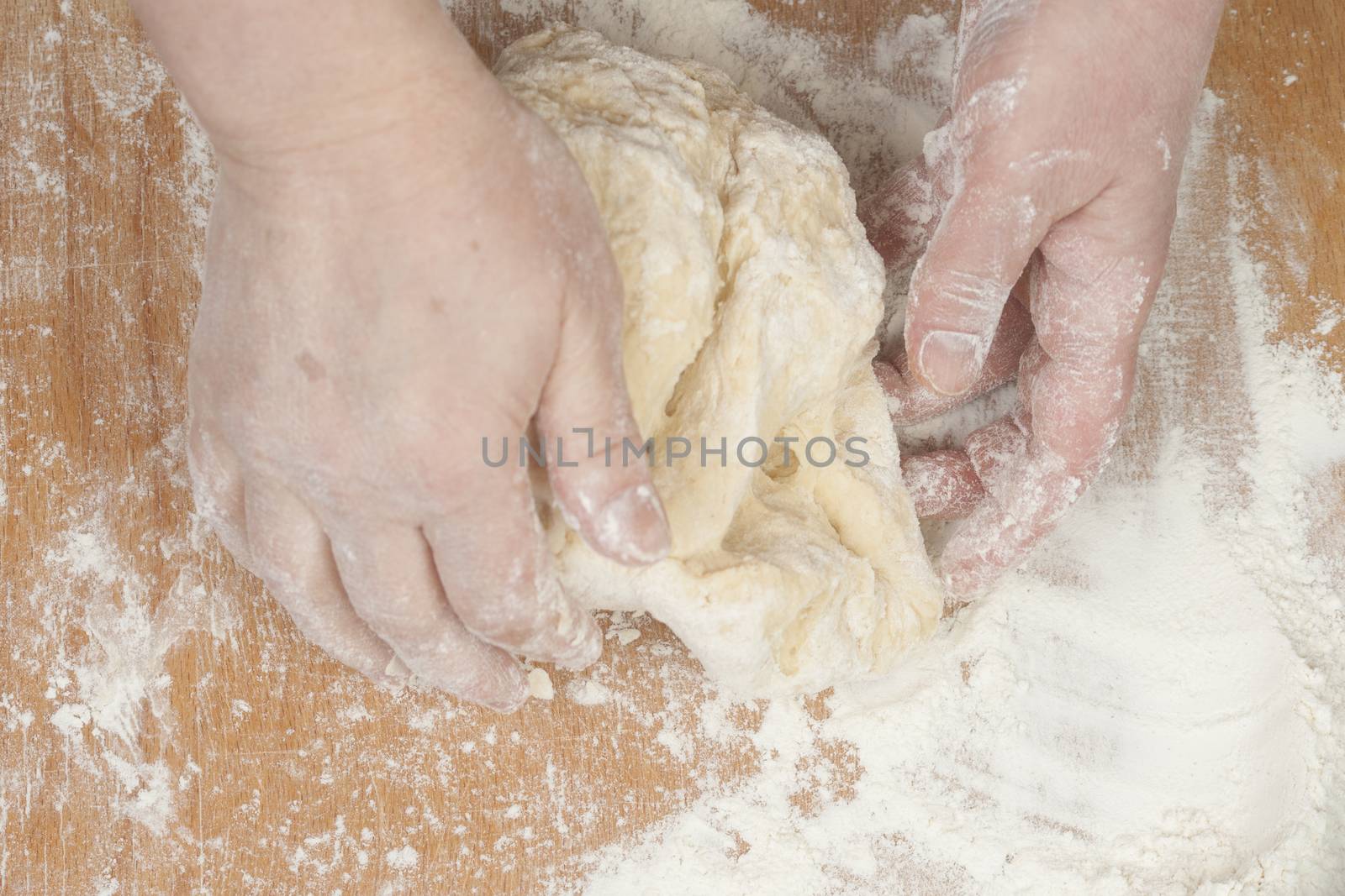 Women's hands preparing fresh yeast dough by kozak