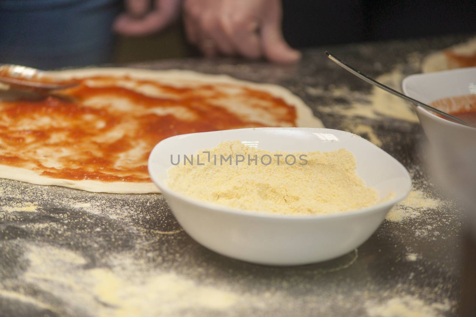 Woman chef with raw dough. Young female in uniform preparing bread dough on table.