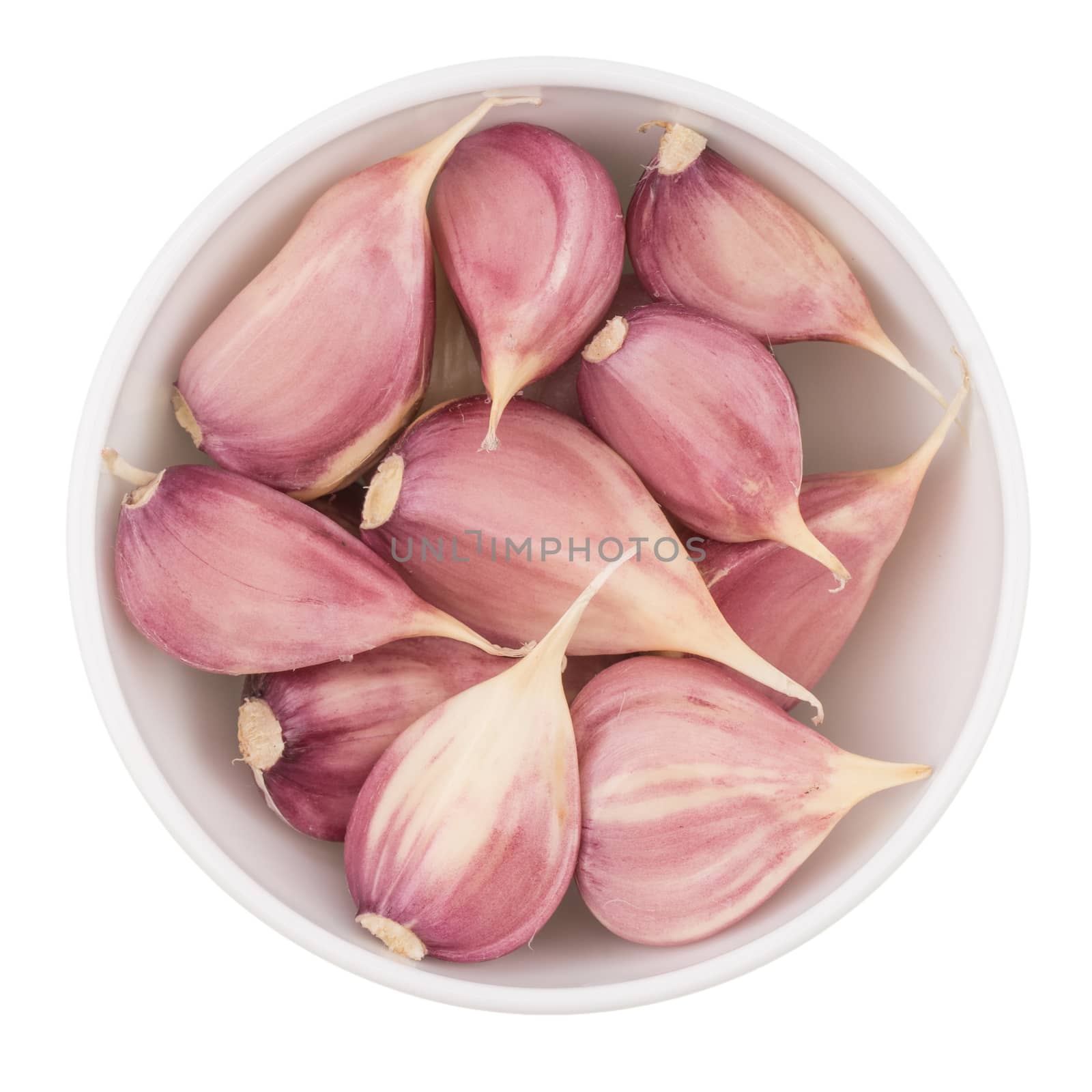 Cloves of garlic on bowl on white background seen from above