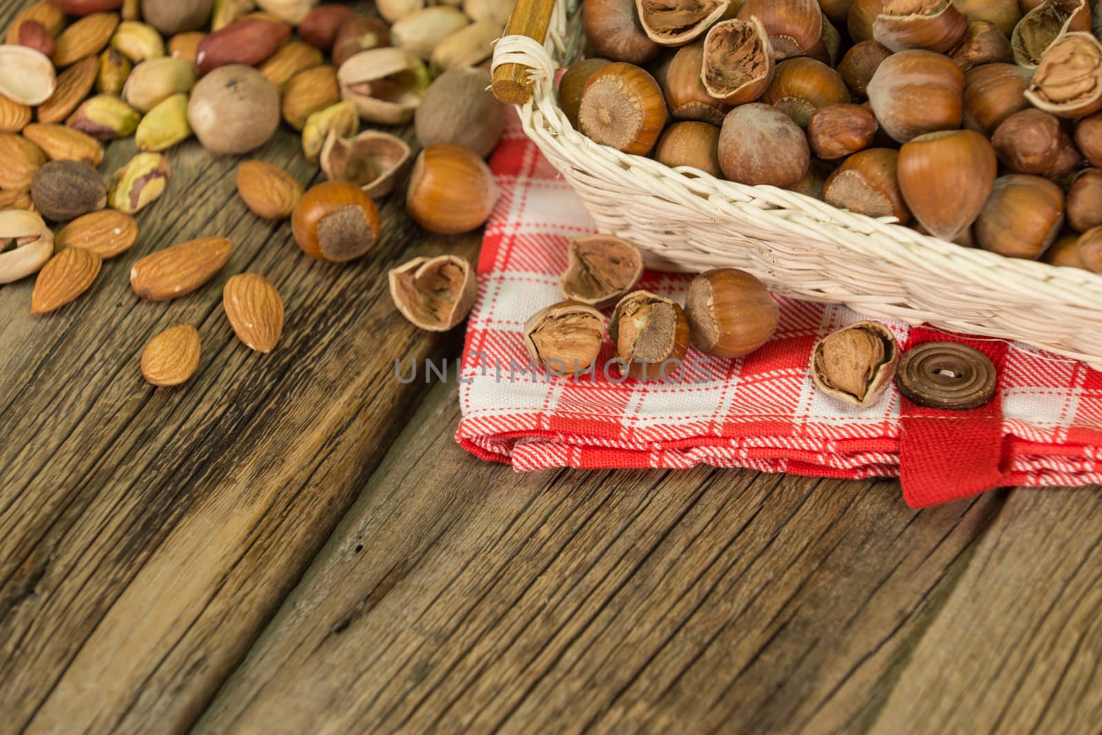 Hazelnuts in small wicker basket, nut mix, selective focus by DGolbay