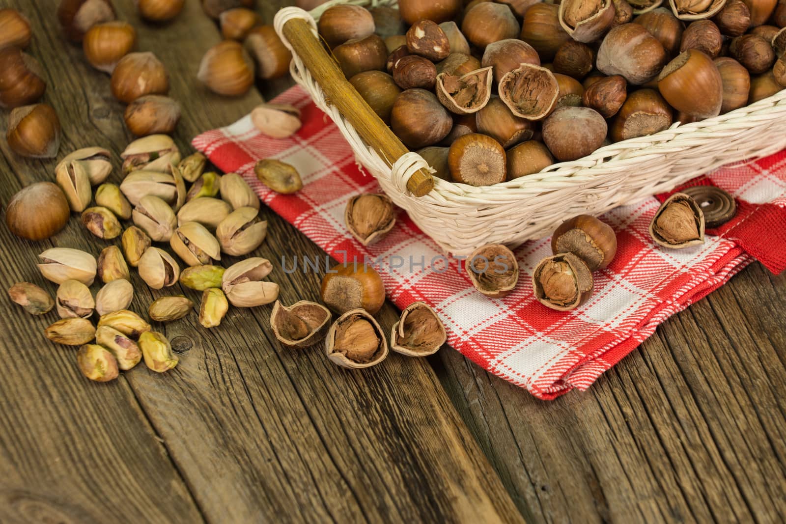 Hazelnuts in small wicker basket, nut mix, selective focus by DGolbay