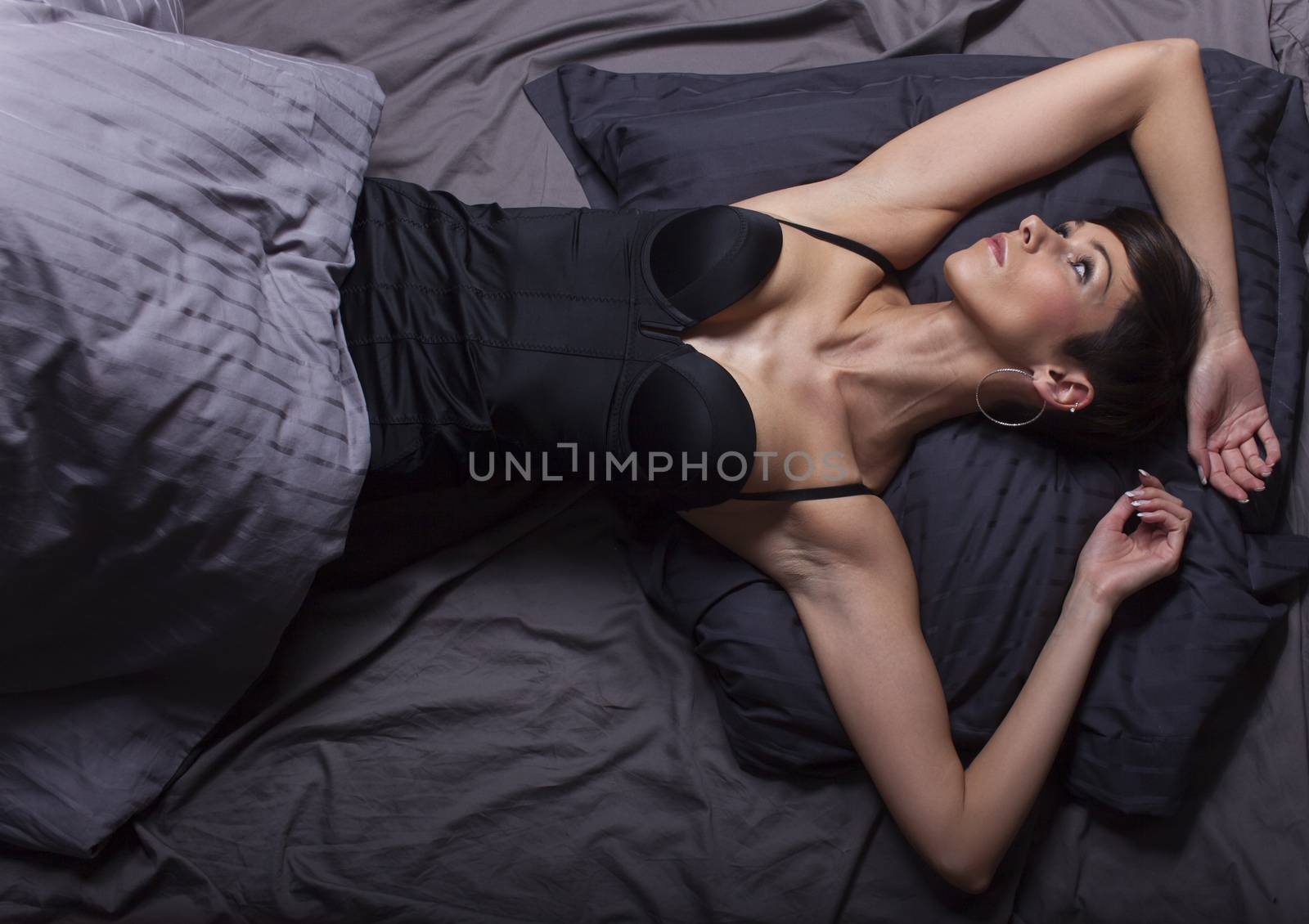 brunette woman lying in bed