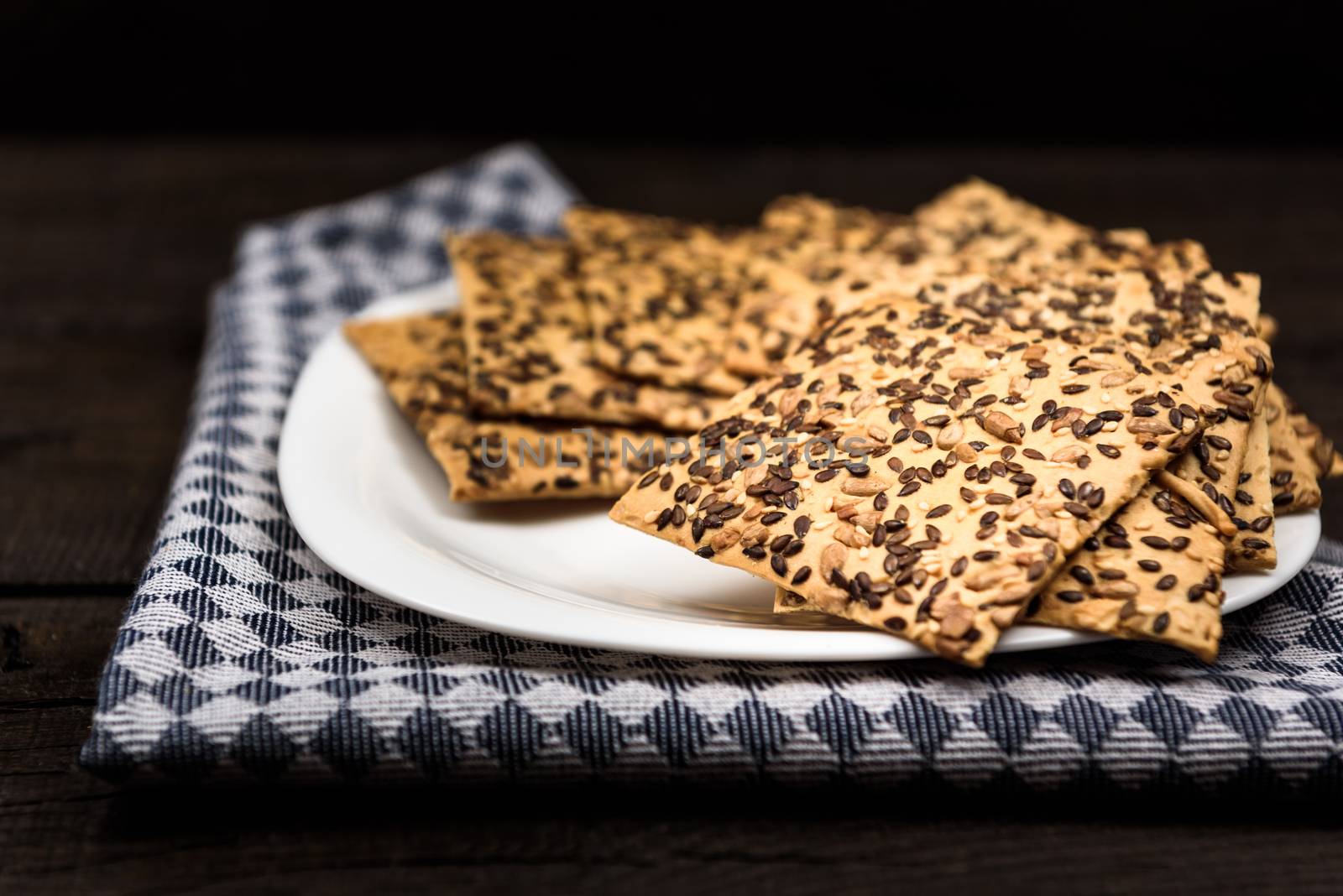 cookies with sunflower seeds and sesame seeds on a white plate with checkered napkin