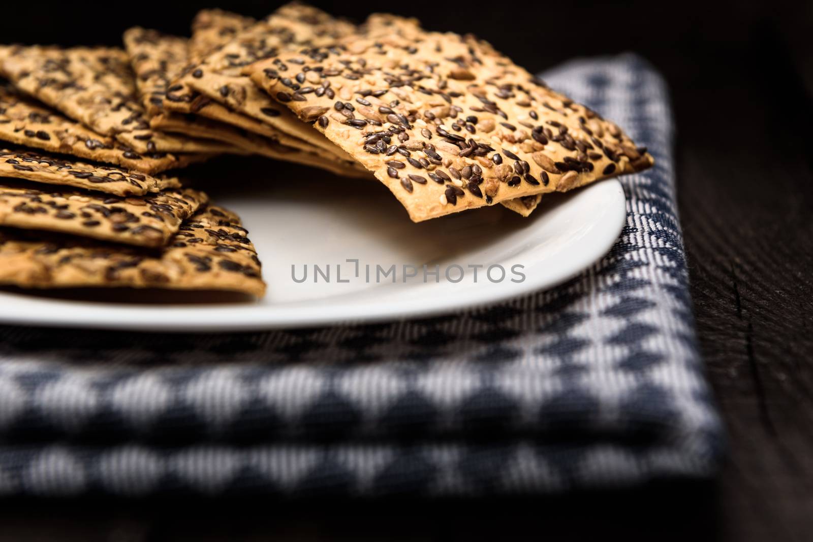 cookies with sunflower seeds and sesame seeds on a white plate with checkered napkin