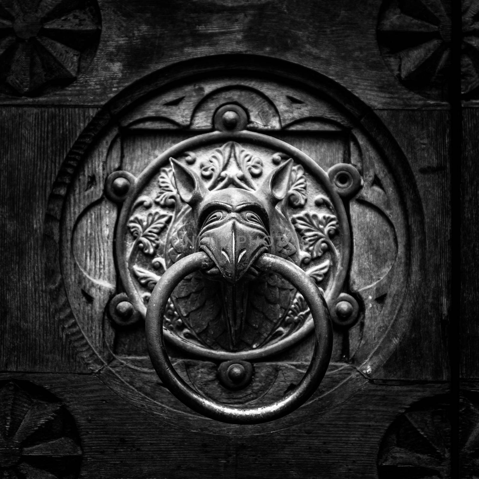 Antique door knocker shaped like monster's head.
