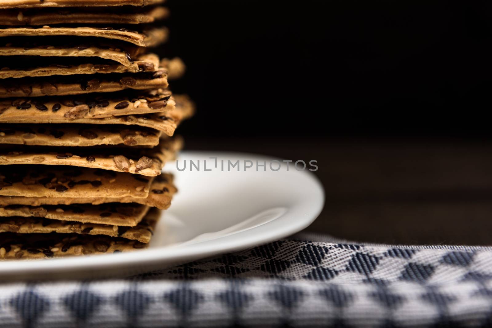 cookies with sunflower seeds and sesame seeds on a white plate with checkered napkin