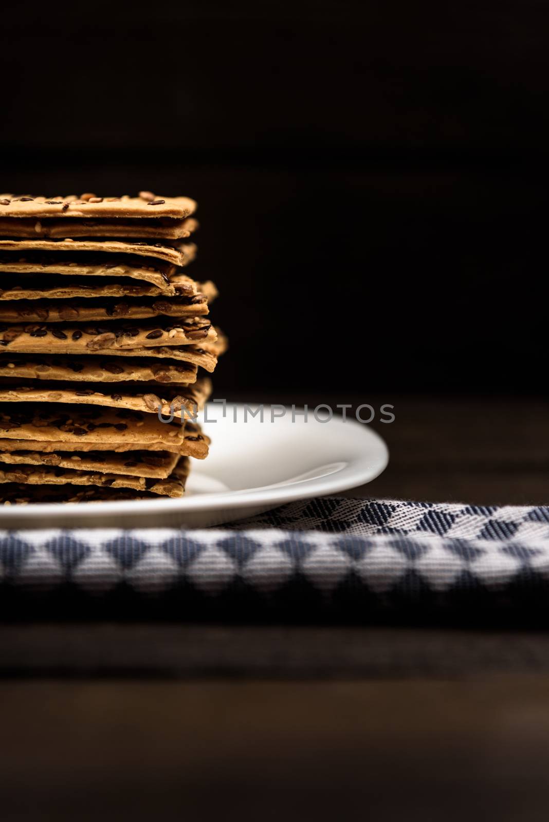 cookies with sunflower seeds and sesame seeds on a white plate with checkered napkin