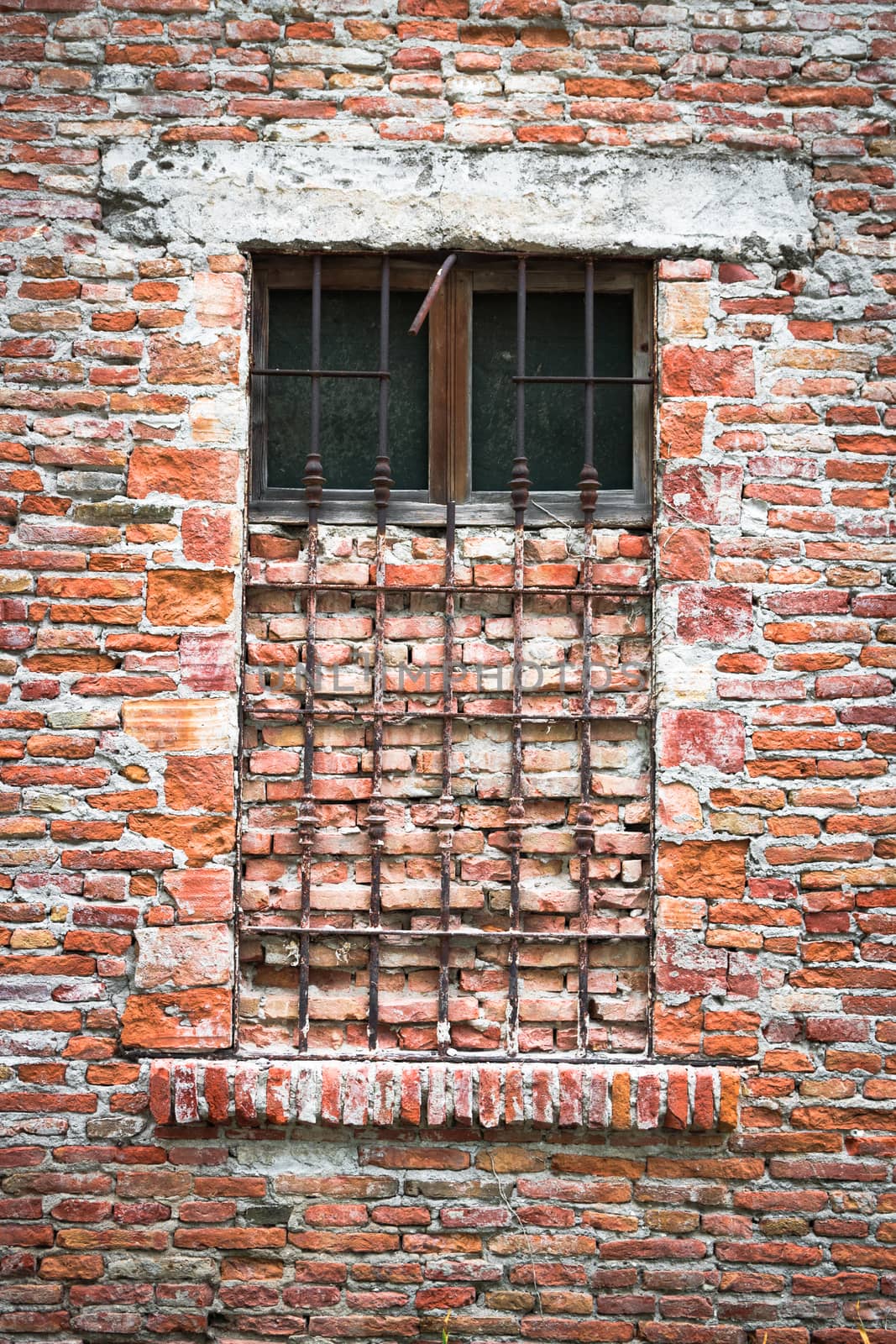 Old window of an abandoned house closed with bricks.
