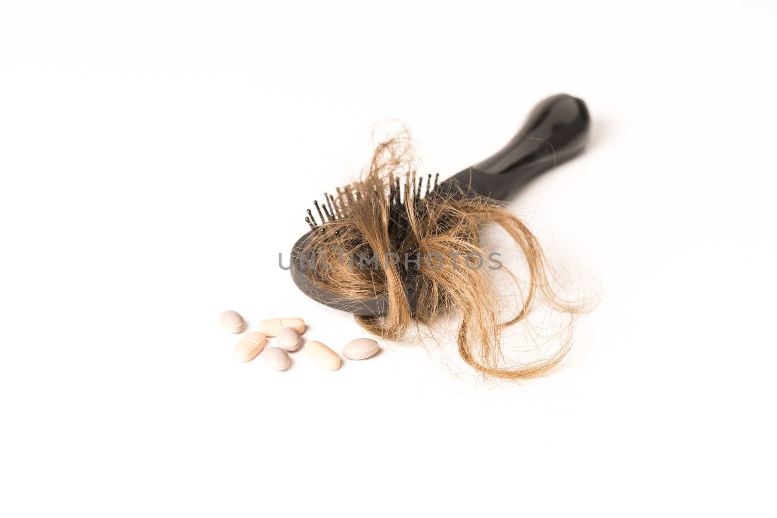 Close-up of hair loss, long hair, alopecia treatment on white background with brush