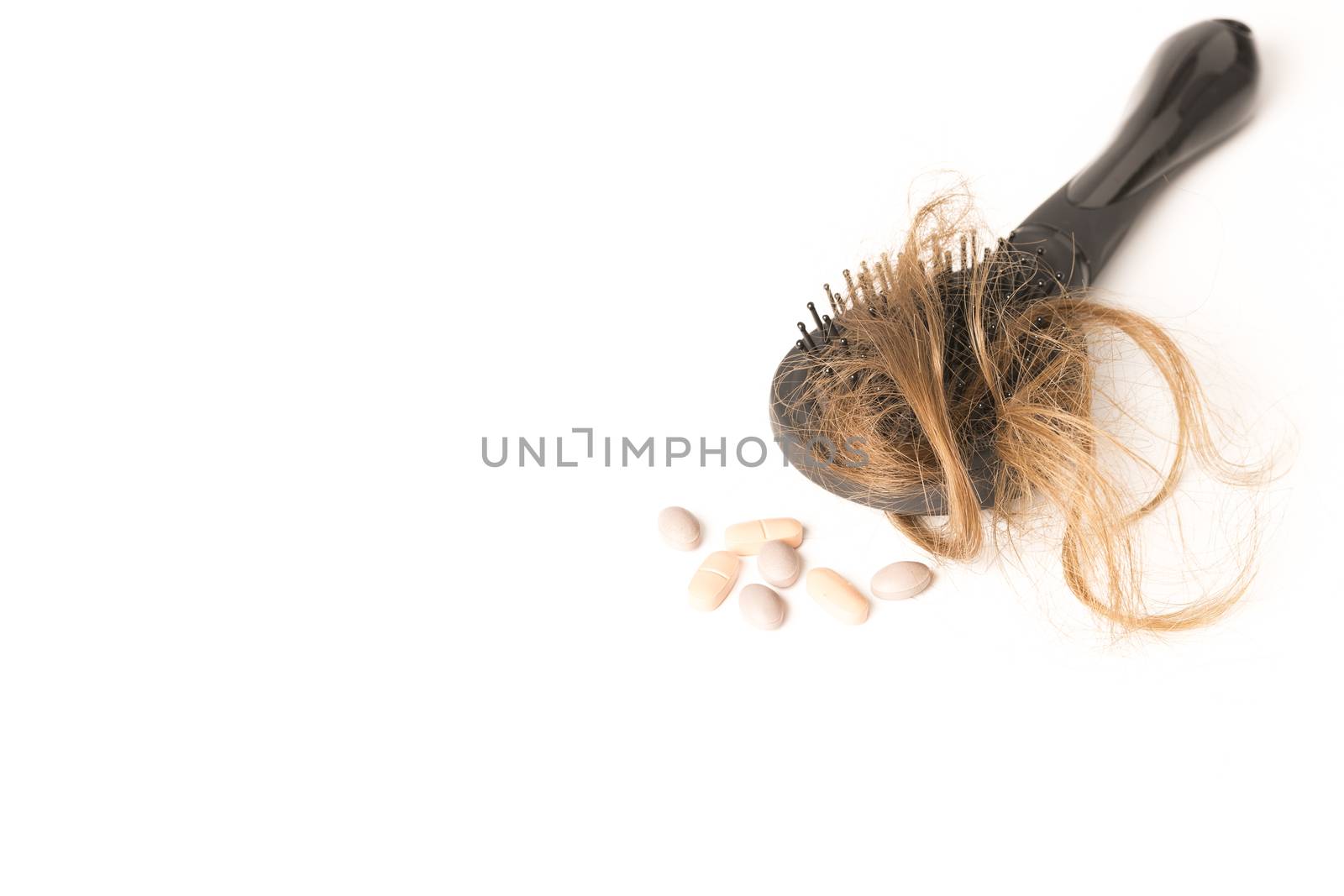 Close-up of hair loss, long hair, alopecia treatment on white background with brush