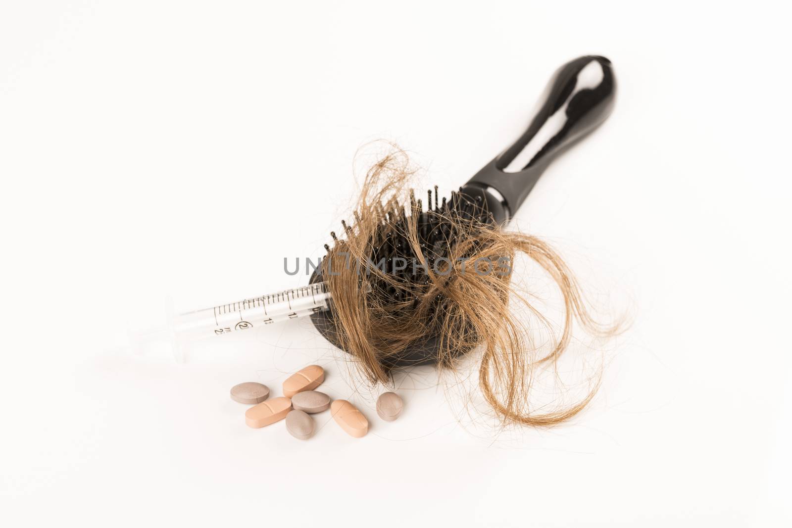 Close-up of hair loss, long hair, alopecia treatment on white background with brush