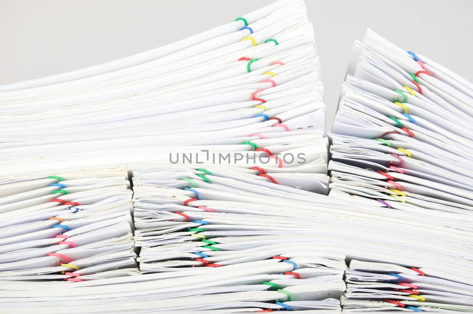 Close up pile overload report and receipt with colorful paperclip place on white background.