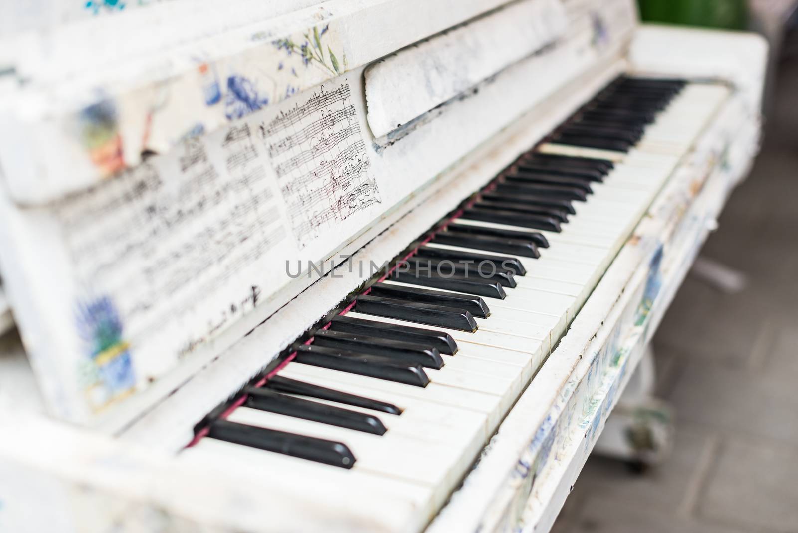 old white piano is on the street by okskukuruza