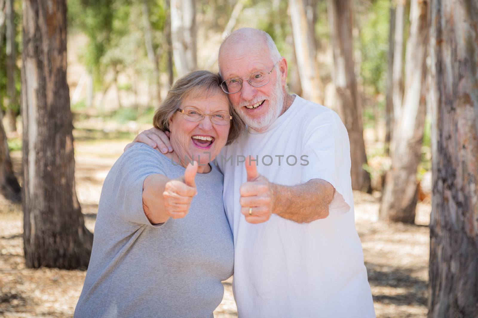 Happy Senior Couple With Thumbs Up Outdoors.