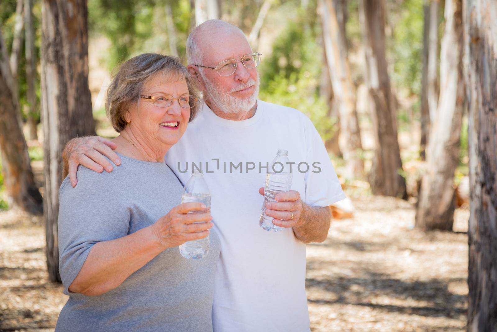 Happy Healthy Senior Couple with Water Bottles by Feverpitched