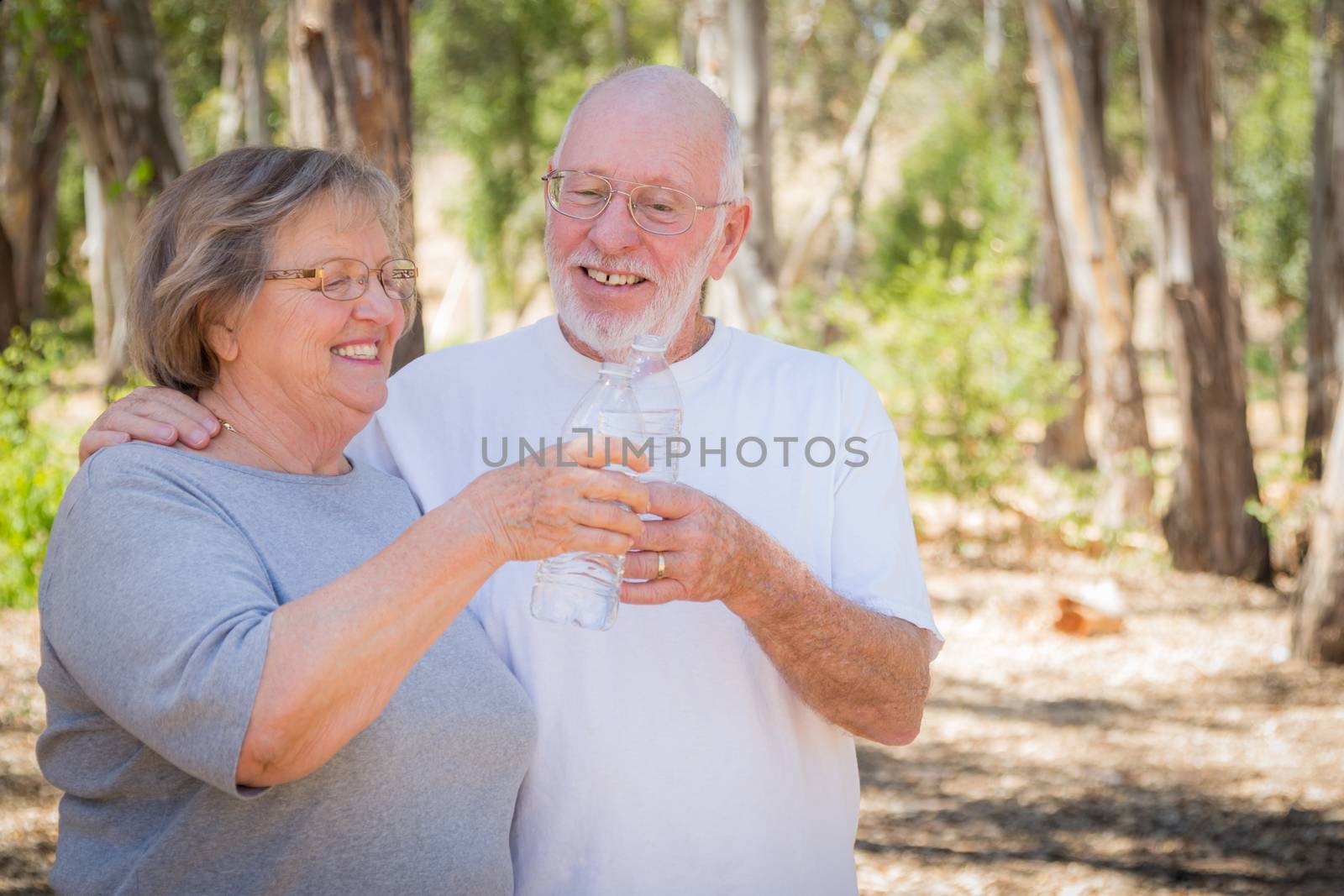 Happy Healthy Senior Couple with Water Bottles by Feverpitched