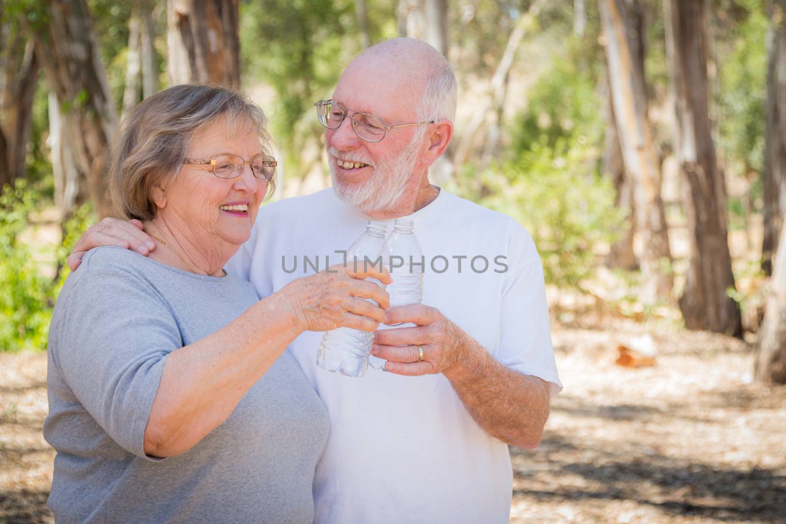 Happy Healthy Senior Couple with Water Bottles by Feverpitched